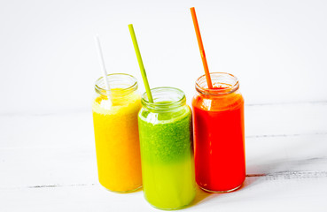 Fresh detox juices in glass bottles on white background