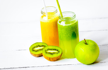Fresh detox juices in glass bottles on white background