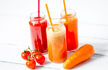 Fresh detox juices in glass bottles on white background