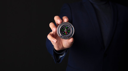 businessman holds compass in his hand