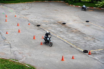 Man is practicing driving a motorcycle in a driving school