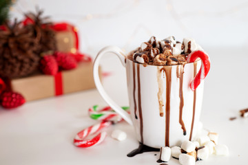 a cup of hot cocoa or chocolate with Christmas present on white table