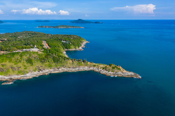 Aerial drone view of a rocky peninsula and a calm, tropical ocean