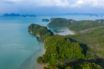 Aerial view of a peaceful, green tropical island covered in jungle and foliage