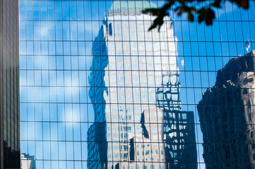 Skyscrapers reflected on a building with windows. Manhattan, New York, United States.