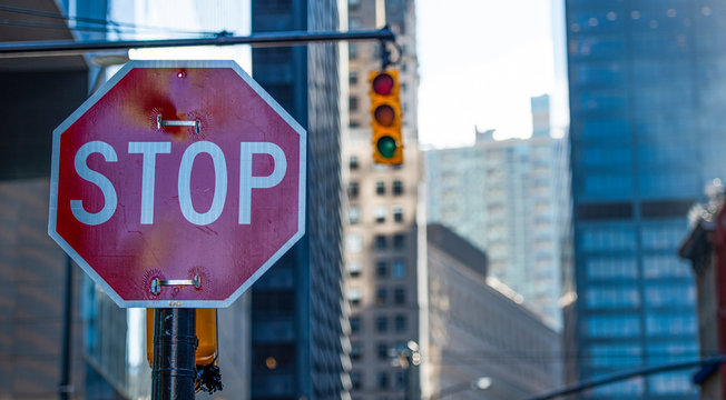 Close-up view of some skyscrapers in Manhattan with a red stop sign in the foreground, New York, United States. - Powered by Adobe