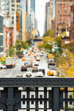(selective focus) Blurred view from the High Line, Street traffic and buildings in Chelsea, New York, USA.
