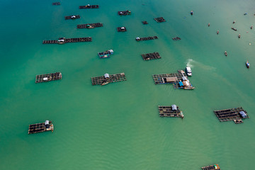 Fototapeta na wymiar Aerial view of large scale traditional floating fish farms on Koh Yao Noi island, Thailand