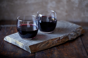 Two glasses of tasty red wine on board in kitchen