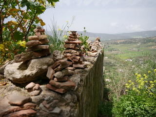 Pile of orange stones in perfect balance on a cliff in the mountains of Ronda, Spain