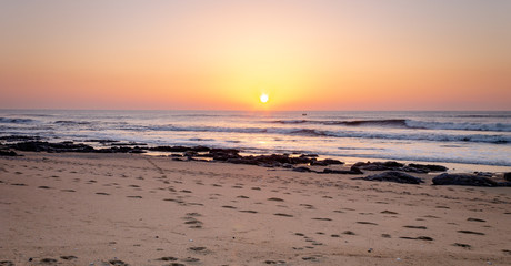 Fototapeta na wymiar Sunset and Footprints at the Beach