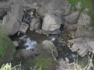 Water flowing through a canyon with pieces of broken buildings in between