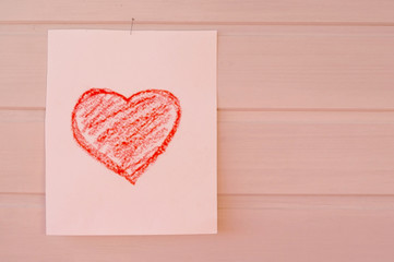 Heart on a sheet of paper drawn by a child and a place for text (white wooden background)         