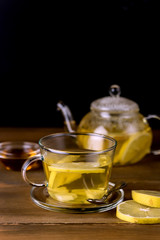 Glass Cup and Glass Teapot with Hot and Tasty Lemon and Ginger Tea Hot Autum Winter Drink Vertical