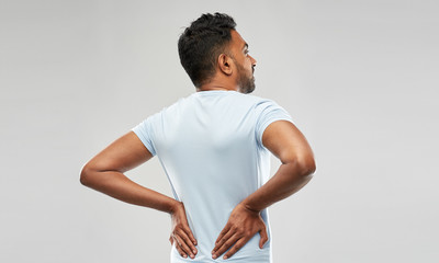 health problem and people concept - unhappy indian man suffering from pain in back or reins over...