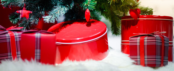 Decorated Christmas tree with baubles and heart surrounded by gift wrapped presents