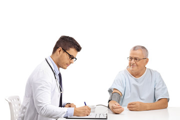 Doctor measuring blood pressure to a mature male patient