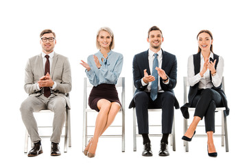 businesspeople applauding and sitting on chairs isolated on white