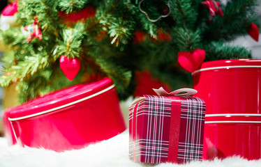 Decorated Christmas tree with baubles and heart surrounded by gift wrapped presents