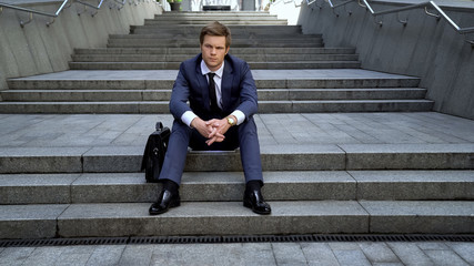 Disappointed male in suit sitting on stairs, bad intertwine, lost opportunities