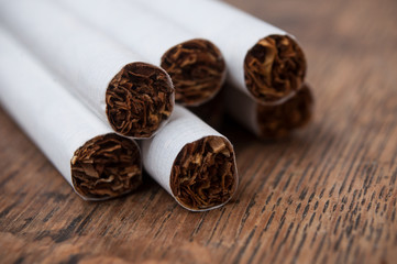 closeup of cigarettes pile on wooden table background