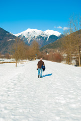 Fototapeta na wymiar One elderly walking on a snowy road