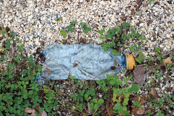 Crushed plastic bottle by the road roadside pollution litter waste horizontal 