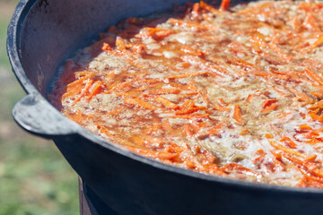 Pilaf cooked in a large cauldron in nature