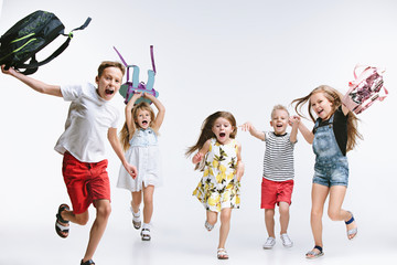 Obraz premium Happiness group of cute and adorable teen children or students are back to school. over white studio background. The friendship, education, childhood, kids fashion concept
