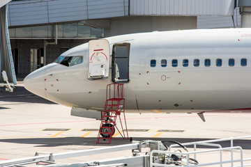 Modern twin engine civil airplane standing on parking place at ground maintenance at International airport.