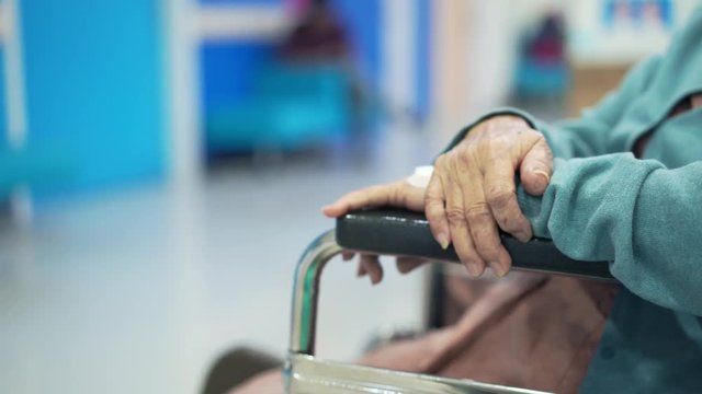 Closeup Elder patient woman hand on wheelchair waiting doctor in hospital