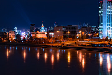 Beautiful night cityscape view of Yekaterinburg center and city pond. City lights reflections on water