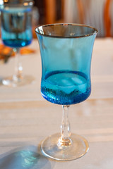 light blue glass with water and ice in it