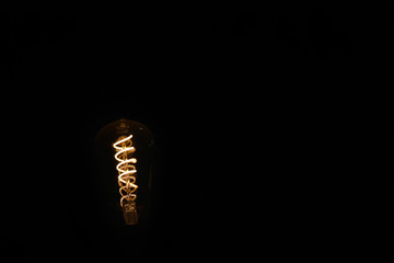 Coil of a bulb lighting in dark. An Idea concept