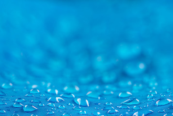Water drops on waterproof nylon fabric. Nylon waterproof fabric with heavy blurred background and focused on the foreground water drops - obrazy, fototapety, plakaty