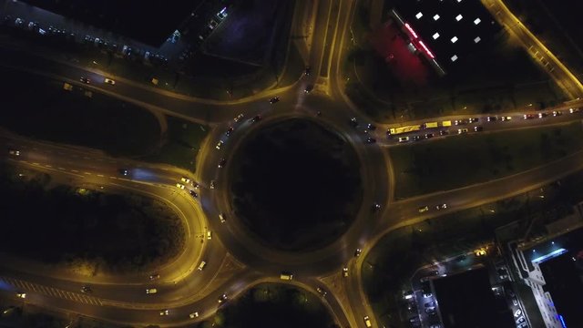 Night overhead view of a roundabout with traffic vehicle. Aerial drone shot