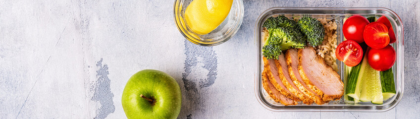 Healthy balanced lunch box with chicken, rice, vegetables.