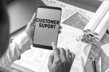 A girl (architect, student, businesswoman) at a table with business accessories, accessories for drawing (plans, rulers) and training with tablet with text Customer support