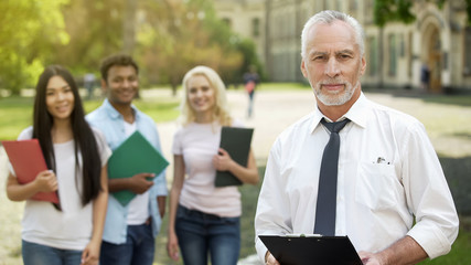 Dean and group of students looking into camera, college education opportunities
