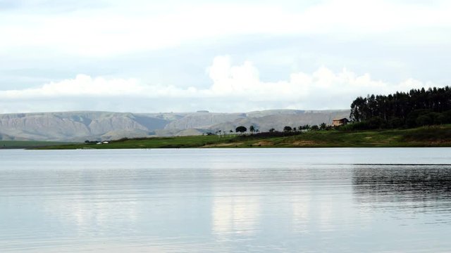 calm scenery of countryside with lake dam and mountains background
