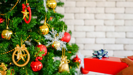 Christmas and tree christmas gifts boxes under the tree, red bauble handing on above.out of focus.