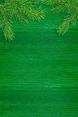 green spruce branches on a green wooden board. Christmas background
