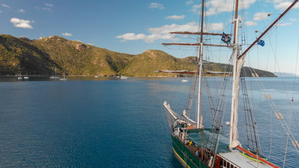 Old sailing ship anchored near an island, aerial view
