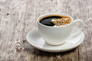 Coffee cup on vintage wooden background