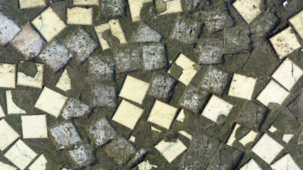 Dirty old colored small ceramic tiles. Texture, background.Broken ceramic mosaic on a concrete basis