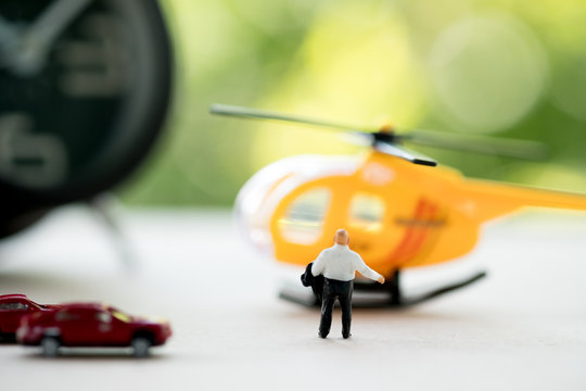 Rear view of miniature businessman walking towards helicopter.