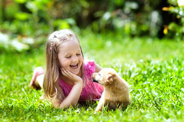 Kids play with puppy. Children and dog in garden.