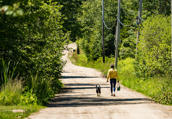 Woman walking dog in park in Maine, USA