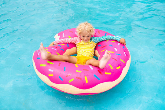 Child in swimming pool on donut float