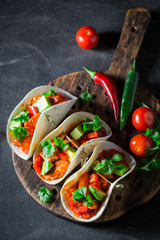 Mexican tacos with spicy sauce on concrete table